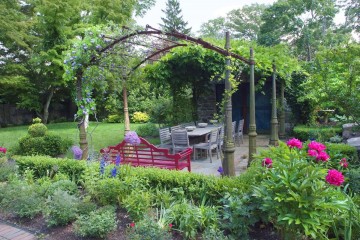 View looking into pergola covered and planting enclosed dining area from the outside.